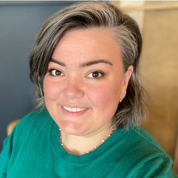 Woman in green shirt smiling.
