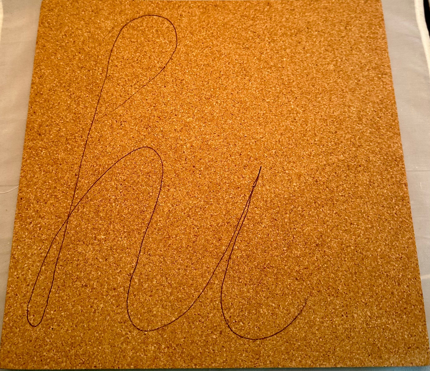 word hi faintly written on corkboard