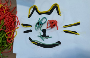 Outline of cat face lined with colored string